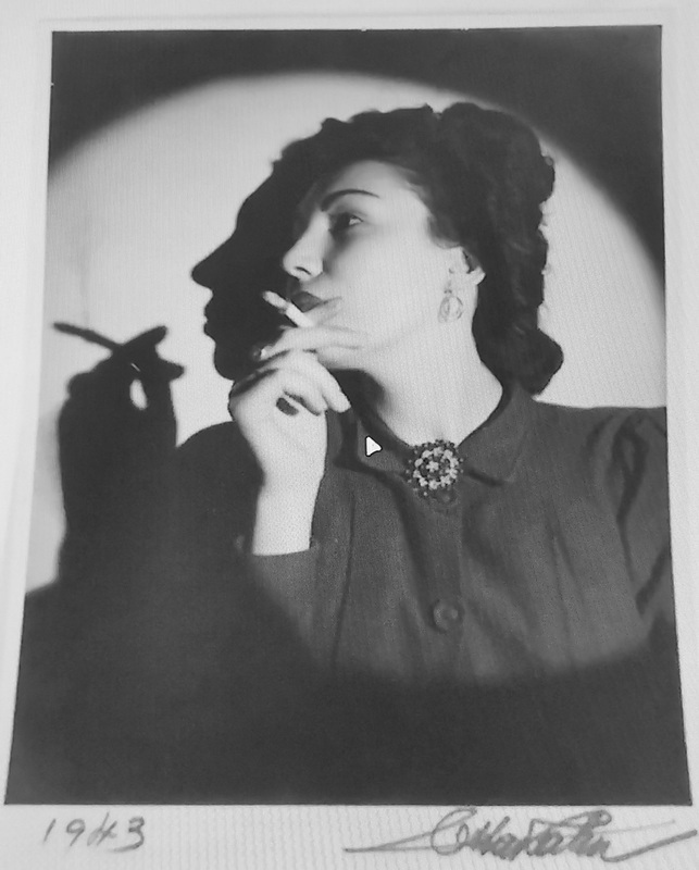 Portrait réalisé par Otta Kahn, mari de la photographe Germaine Kanova. Portrait noir et blanc d'une femme qui fume. Ombre portée du profil de la femme sur le fond dans un cercle blanc.